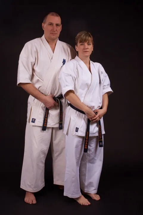 Sensei Beata i Piotr Machulec w pełnej postawie w karategi, ciemnobrązowe tło